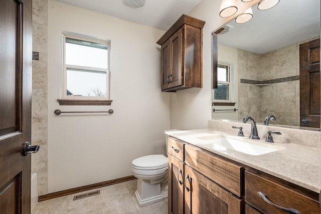 bathroom with vanity, baseboards, visible vents, a shower, and toilet