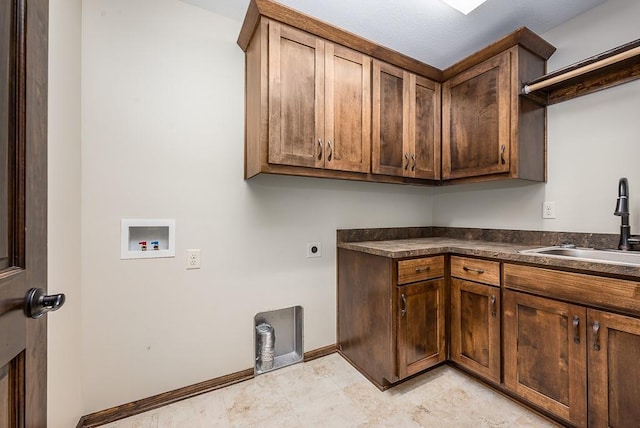 washroom with washer hookup, a sink, cabinet space, baseboards, and hookup for an electric dryer