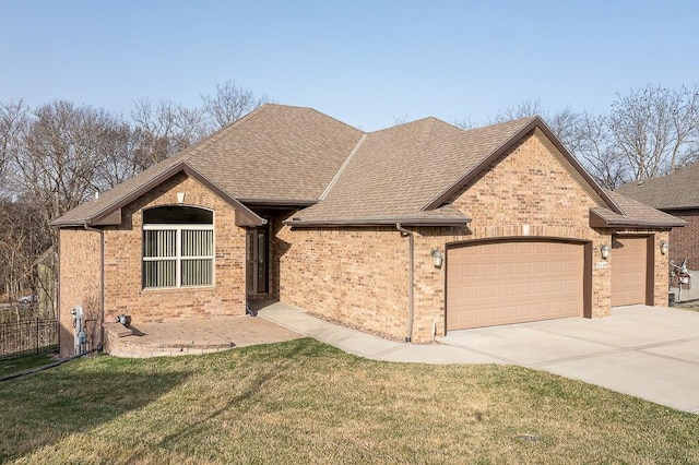 view of front of property featuring a front yard, brick siding, a garage, and a shingled roof