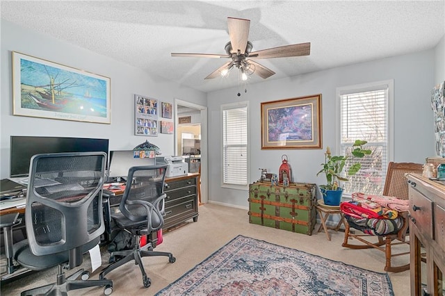 carpeted home office featuring a textured ceiling and a ceiling fan