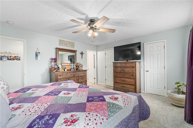 bedroom featuring visible vents, baseboards, carpet floors, a textured ceiling, and a ceiling fan