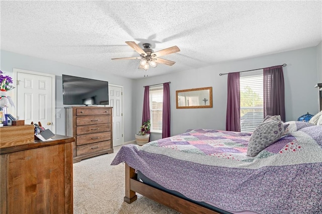 bedroom featuring a textured ceiling, a ceiling fan, and carpet floors