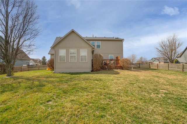 back of house with a yard, a fenced backyard, and a wooden deck