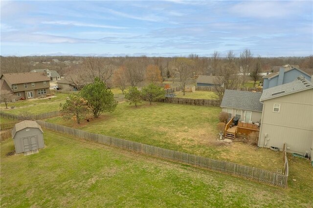 view of yard featuring a fenced backyard, a storage shed, a rural view, an outdoor structure, and a wooden deck