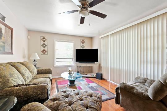 6745 Cleveland Ave, Kansas City, MO 64132 - living room with baseboards, a ceiling fan, and wood finished floors
