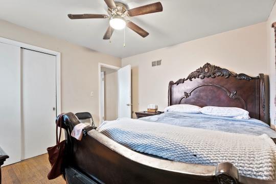 6745 Cleveland Ave, Kansas City, MO 64132 - bedroom with a ceiling fan, a closet, wood finished floors, and visible vents