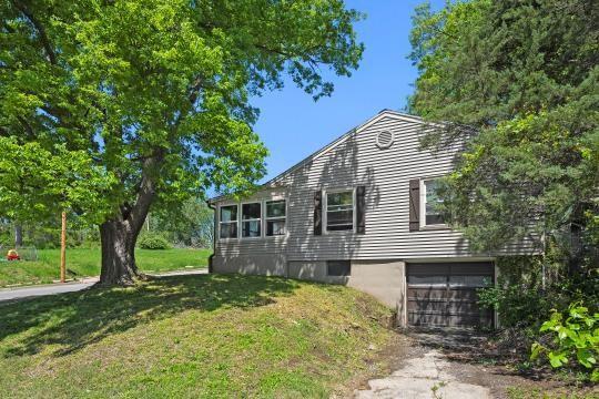 6745 Cleveland Ave, Kansas City, MO 64132 - view of property exterior featuring a yard, an attached garage, and driveway