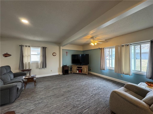 living room featuring baseboards, a textured ceiling, and a ceiling fan