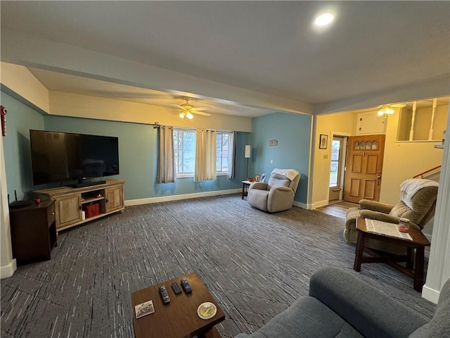 living area featuring a ceiling fan, baseboards, and dark colored carpet