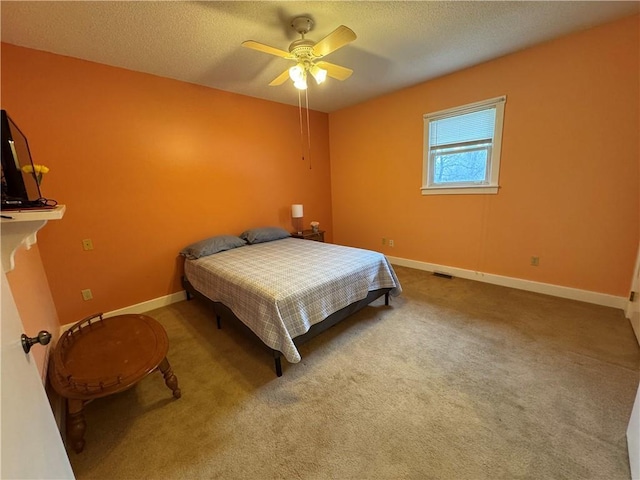 carpeted bedroom featuring a textured ceiling, baseboards, and a ceiling fan