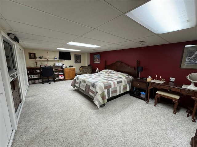 bedroom featuring a paneled ceiling, light carpet, and visible vents