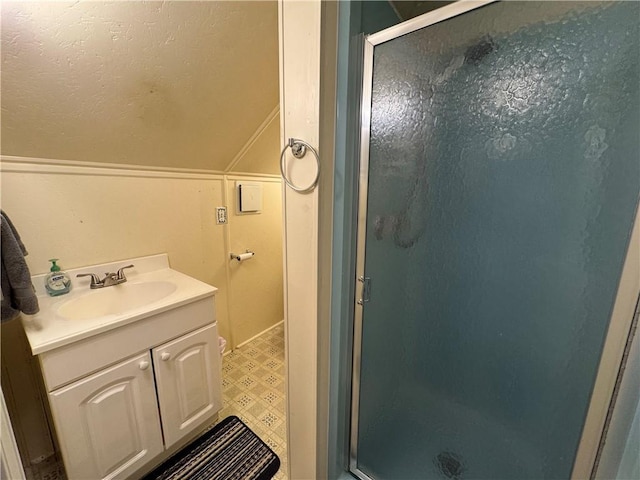 full bath featuring vanity, a shower stall, lofted ceiling, and tile patterned floors