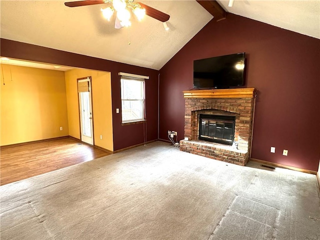 unfurnished living room featuring visible vents, a ceiling fan, lofted ceiling with beams, carpet floors, and a brick fireplace