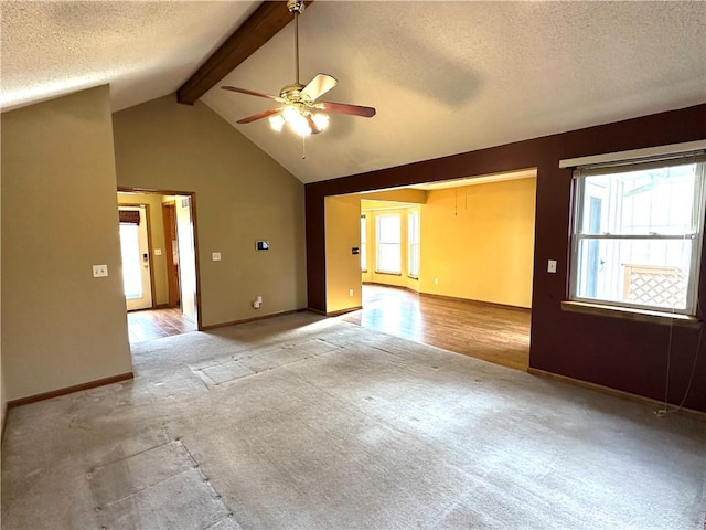 spare room featuring a textured ceiling, beam ceiling, light colored carpet, and ceiling fan