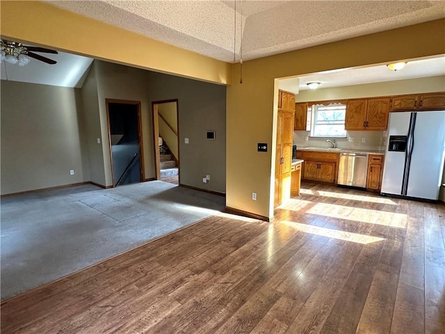 unfurnished living room with light wood-style flooring, baseboards, stairs, and a ceiling fan