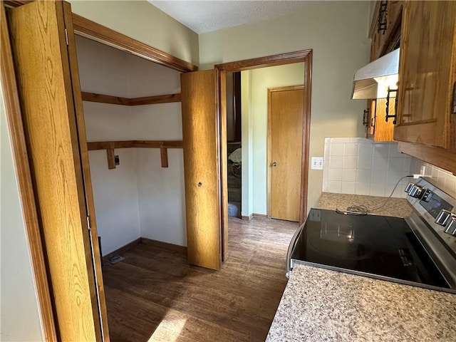 kitchen with backsplash, extractor fan, dark wood finished floors, stainless steel electric stove, and light countertops