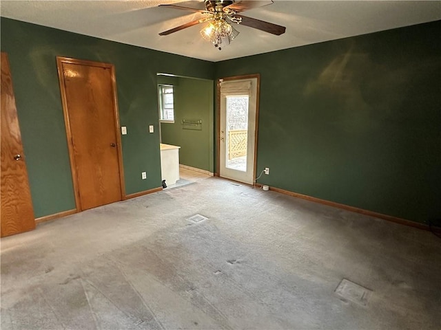 spare room with baseboards, light carpet, and a ceiling fan