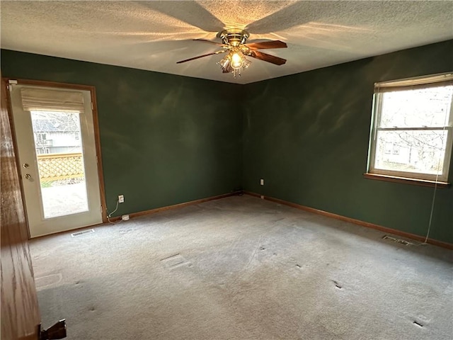 spare room featuring visible vents, baseboards, a textured ceiling, and a ceiling fan