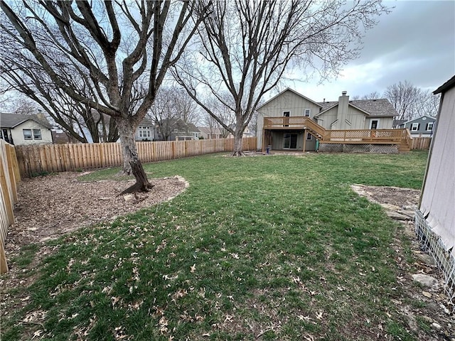 view of yard with stairway, a wooden deck, and a fenced backyard