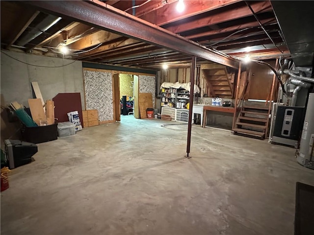 unfinished basement featuring gas water heater and stairs