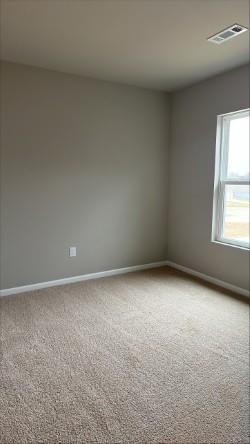 spare room with visible vents, baseboards, and carpet