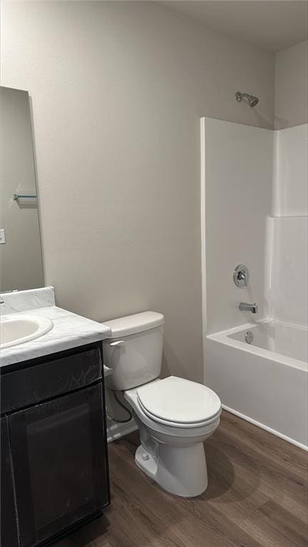 full bath with vanity, shower / tub combination, toilet, and wood finished floors