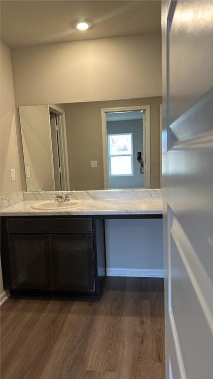 bathroom featuring vanity, recessed lighting, and wood finished floors