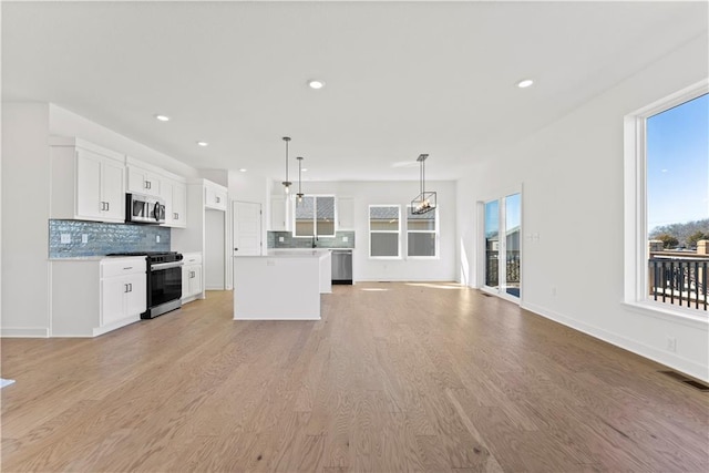 10612 N Jefferson St, Kansas City, MO 64155 - kitchen featuring visible vents, light wood-style flooring, appliances with stainless steel finishes, and open floor plan
