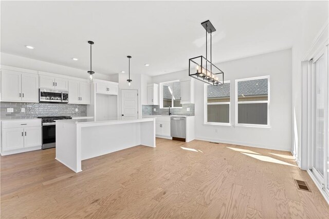 10612 N Jefferson St, Kansas City, MO 64155 - kitchen featuring white cabinetry, stainless steel appliances, and light wood-style floors