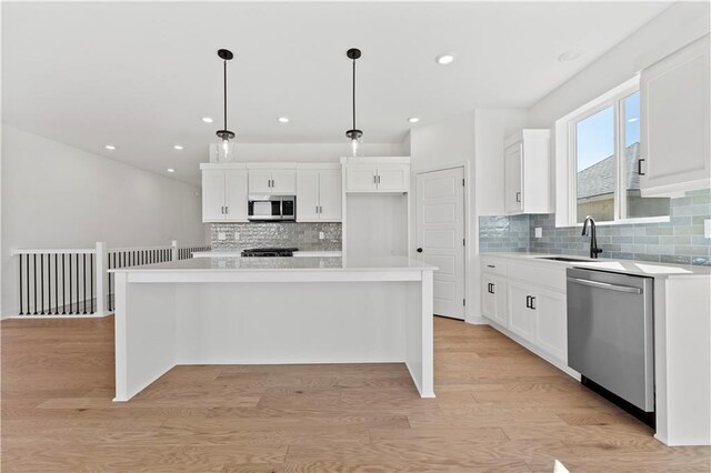 10612 N Jefferson St, Kansas City, MO 64155 - kitchen featuring light wood finished floors, appliances with stainless steel finishes, white cabinetry, and a sink