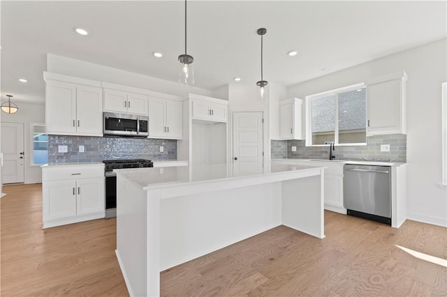 10612 N Jefferson St, Kansas City, MO 64155 - kitchen featuring white cabinets, stainless steel appliances, light wood-type flooring, and light countertops