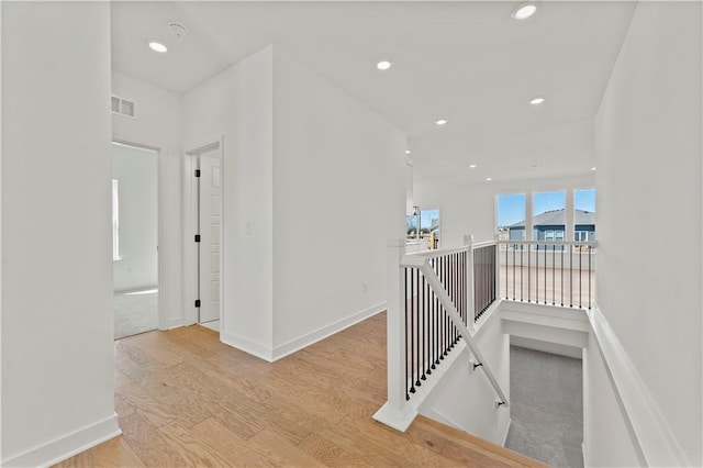 10612 N Jefferson St, Kansas City, MO 64155 - corridor with wood finished floors, visible vents, baseboards, recessed lighting, and an upstairs landing
