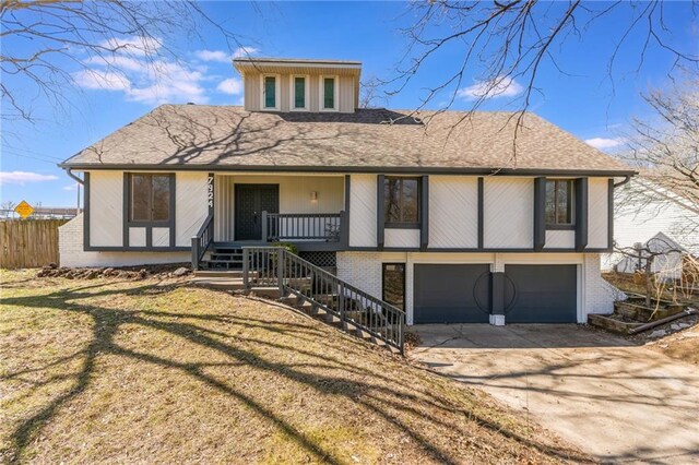 view of front of property with covered porch, concrete driveway, an attached garage, brick siding, and stairs