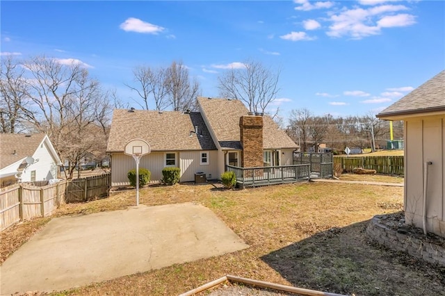 back of house featuring central AC unit, fence, a chimney, a deck, and a patio area