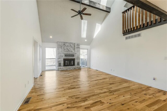unfurnished living room featuring visible vents, high vaulted ceiling, a ceiling fan, and wood finished floors