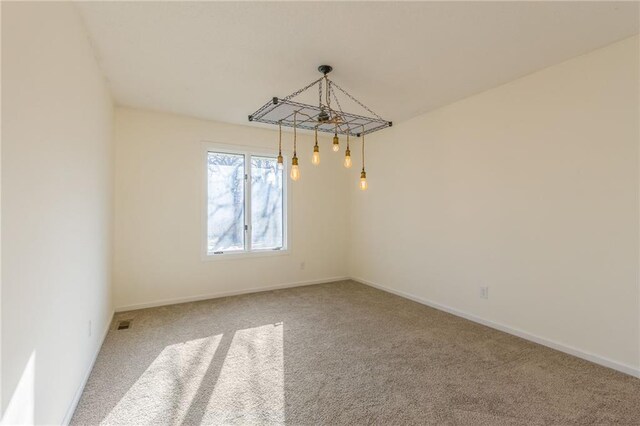 carpeted empty room with visible vents and baseboards