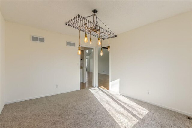spare room featuring visible vents, carpet flooring, and baseboards