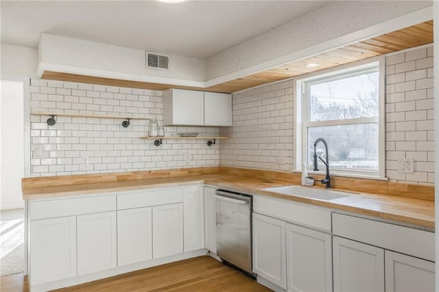 kitchen featuring visible vents, open shelves, butcher block countertops, dishwasher, and a sink