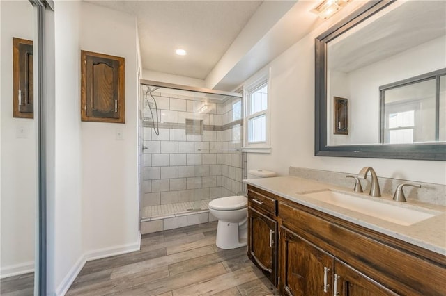 full bathroom featuring a stall shower, toilet, baseboards, and wood finished floors