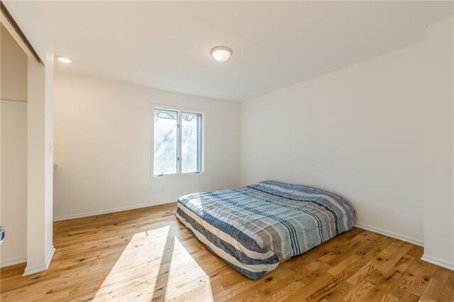 bedroom featuring light wood-style flooring and baseboards