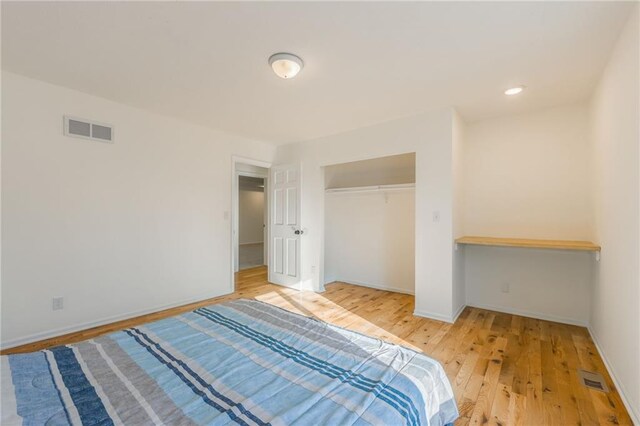 bedroom featuring visible vents, baseboards, a closet, and light wood finished floors