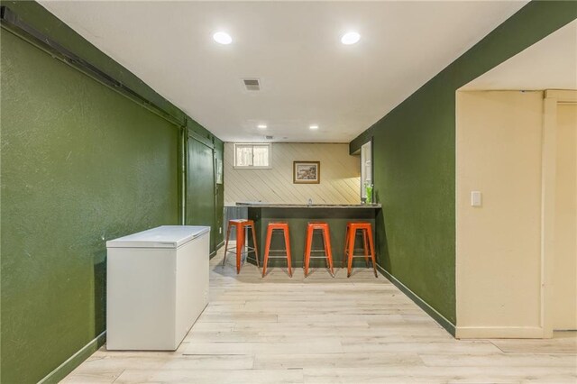 bar with visible vents, a dry bar, recessed lighting, light wood-style floors, and refrigerator