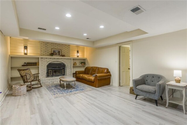 living room featuring a tray ceiling, recessed lighting, wood finished floors, and visible vents