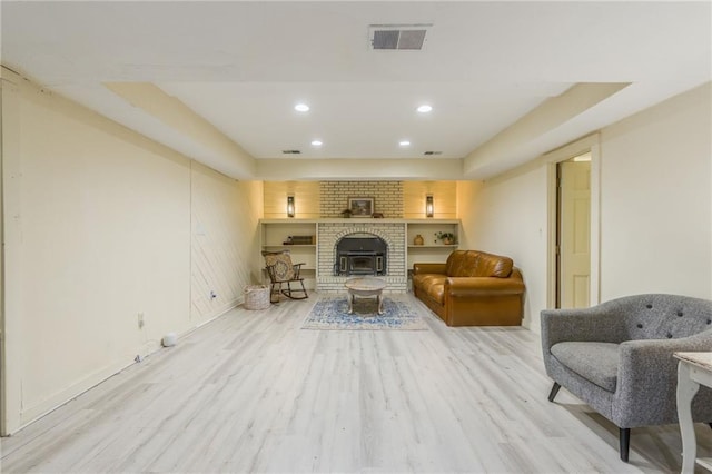 living area featuring visible vents, recessed lighting, light wood finished floors, baseboards, and a brick fireplace