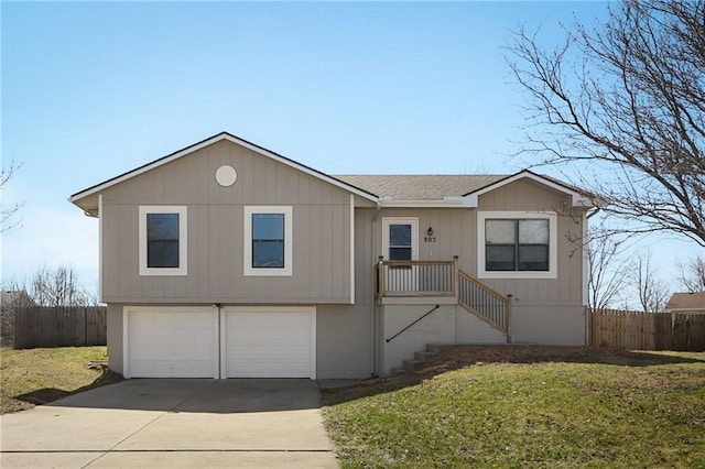 view of front of home with a garage, a front lawn, driveway, and fence