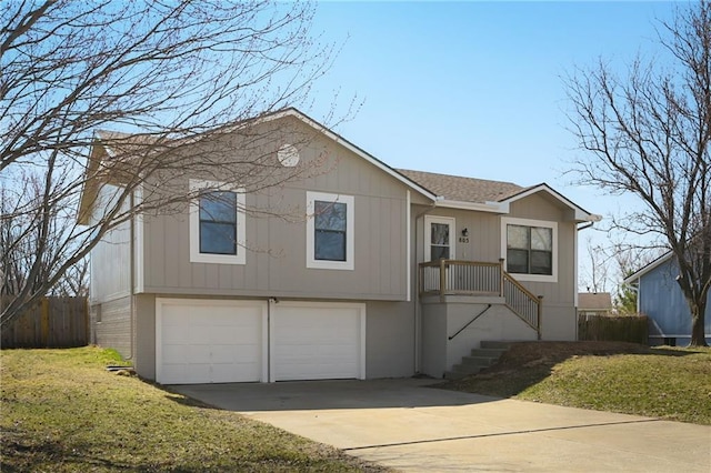 view of front facade with driveway, fence, roof with shingles, a front yard, and an attached garage