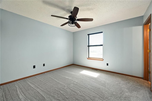 carpeted empty room with visible vents, a textured ceiling, baseboards, and ceiling fan