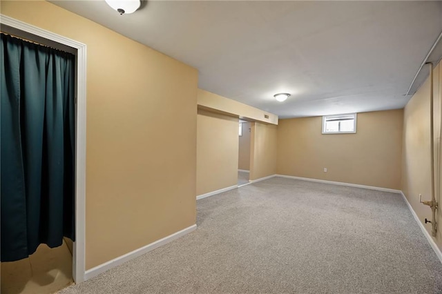 basement featuring baseboards and carpet flooring