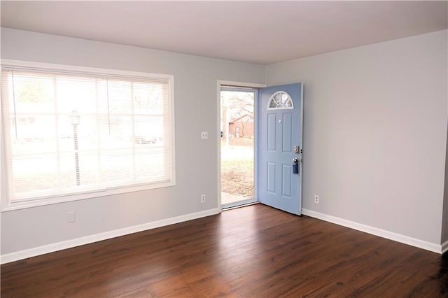 foyer entrance with baseboards and dark wood-style flooring