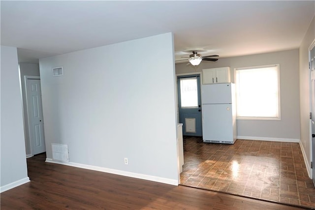 kitchen with visible vents, baseboards, ceiling fan, freestanding refrigerator, and dark wood-style flooring